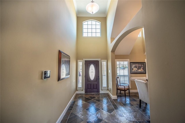 entrance foyer with plenty of natural light, ornamental molding, and a high ceiling