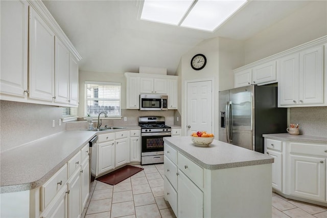 3307 Fredrick Ct, College Station, TX 77845 - kitchen with stainless steel appliances, a sink, vaulted ceiling, a kitchen island, and light tile patterned flooring
