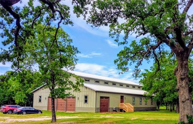 view of front facade featuring board and batten siding, an outdoor structure, and a front yard