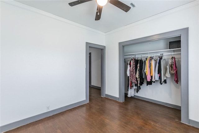 unfurnished bedroom with ceiling fan, dark hardwood / wood-style floors, a closet, and crown molding