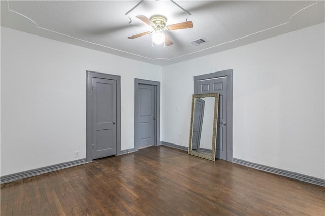 empty room featuring ceiling fan and dark hardwood / wood-style floors