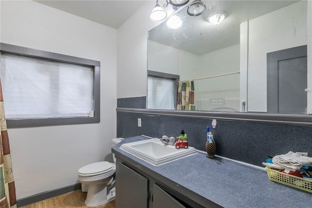 bathroom featuring walk in shower, vanity, toilet, and hardwood / wood-style flooring