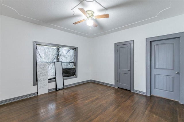 unfurnished bedroom with ceiling fan and dark wood-type flooring