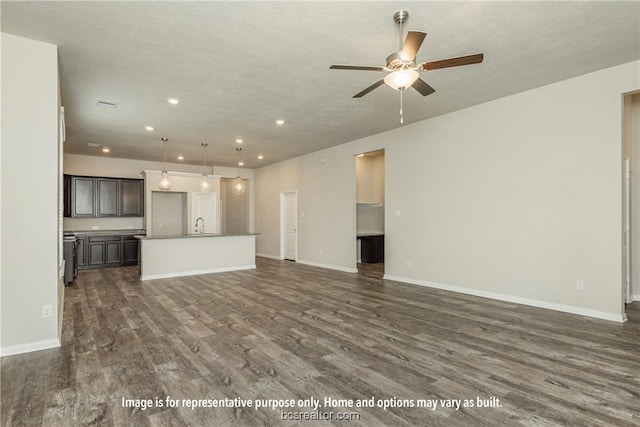 unfurnished living room with a textured ceiling, dark hardwood / wood-style floors, and ceiling fan