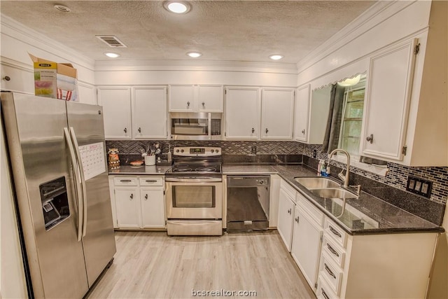 kitchen featuring white cabinetry, sink, stainless steel appliances, light hardwood / wood-style floors, and a textured ceiling