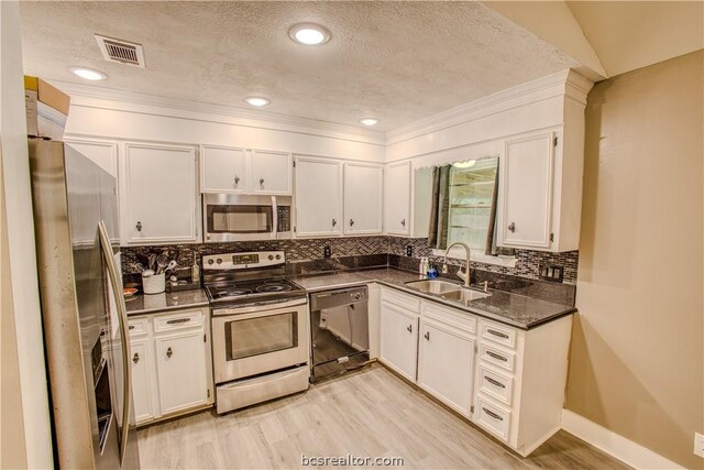 kitchen featuring backsplash, sink, a textured ceiling, white cabinetry, and stainless steel appliances