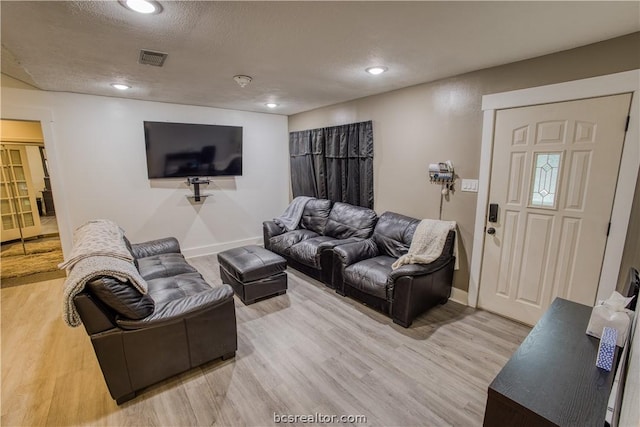 living room with a textured ceiling and hardwood / wood-style flooring