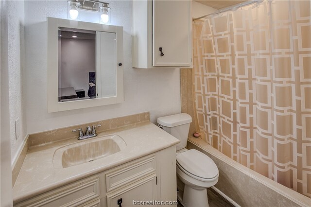 full bathroom featuring vanity, shower / bath combination with curtain, and toilet