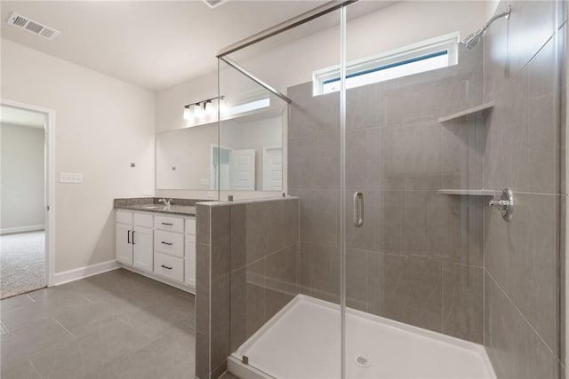 bathroom featuring a shower with door, vanity, and tile patterned flooring