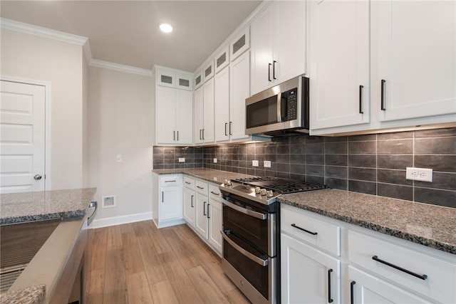 kitchen with light stone countertops, appliances with stainless steel finishes, light hardwood / wood-style floors, and white cabinetry