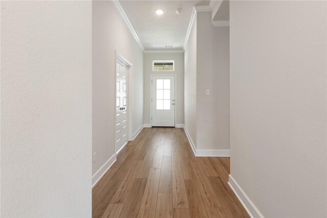 doorway to outside featuring light hardwood / wood-style floors and ornamental molding