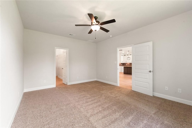 unfurnished bedroom with carpet flooring, ensuite bathroom, and ceiling fan