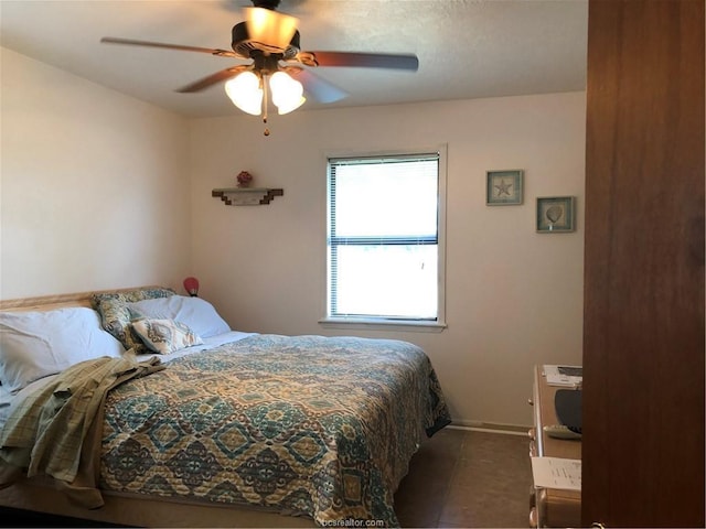 tiled bedroom with a ceiling fan