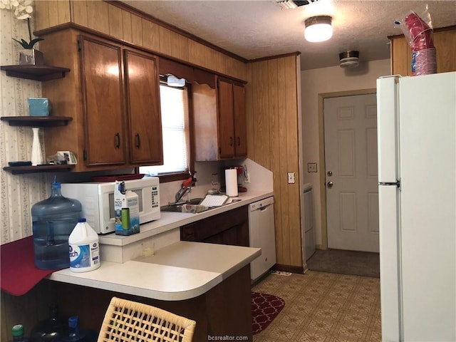 kitchen with white appliances, a sink, light countertops, tile patterned floors, and open shelves