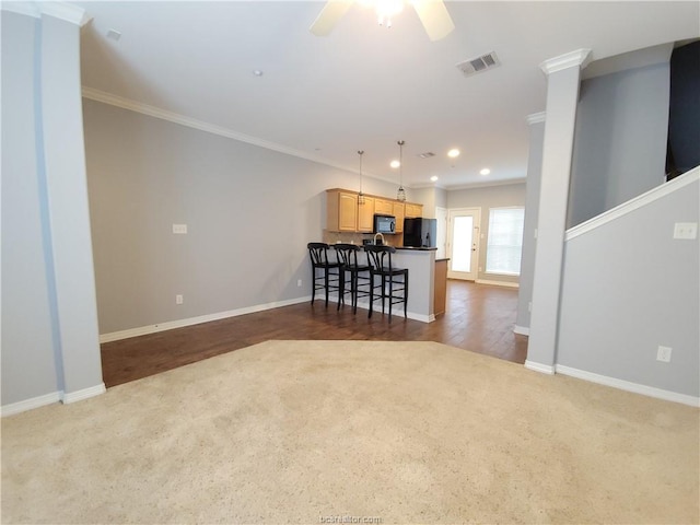 unfurnished living room with dark carpet, crown molding, and ceiling fan