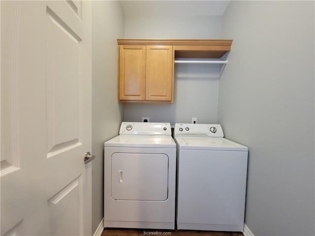 washroom with washing machine and dryer and cabinets