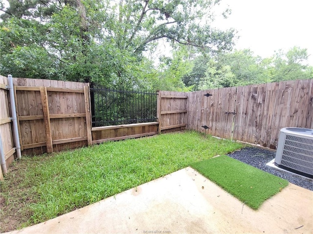 view of yard with central AC and a patio area