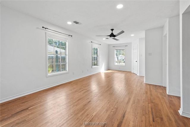 unfurnished room featuring a wealth of natural light, light hardwood / wood-style flooring, and ceiling fan