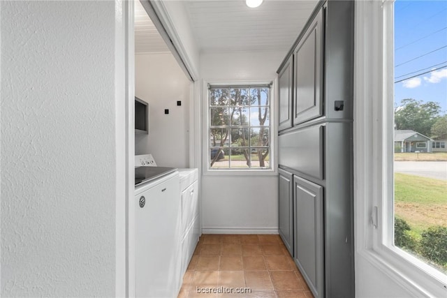 washroom with cabinets, a wealth of natural light, and washing machine and clothes dryer