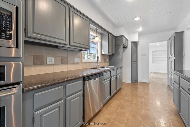 kitchen featuring decorative backsplash, stainless steel appliances, sink, decorative light fixtures, and gray cabinets