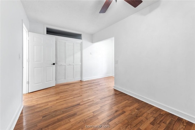 unfurnished bedroom with wood-type flooring, a closet, and ceiling fan