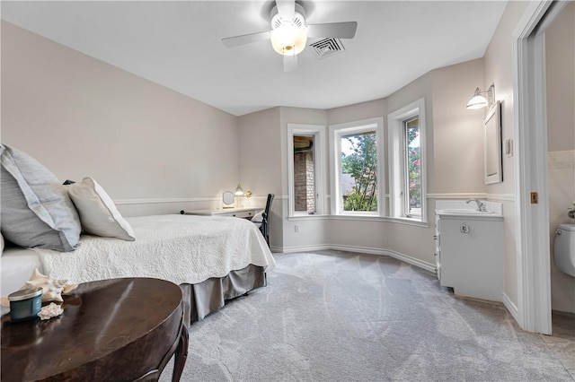 bedroom featuring a sink, visible vents, light carpet, a ceiling fan, and baseboards