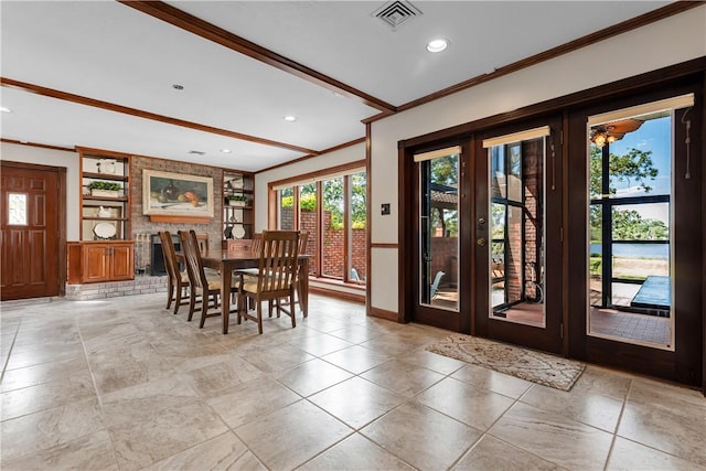 dining room featuring french doors, baseboards, visible vents, built in shelves, and crown molding