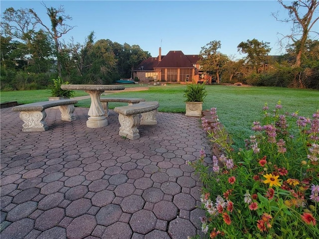 view of property's community featuring a patio and a lawn