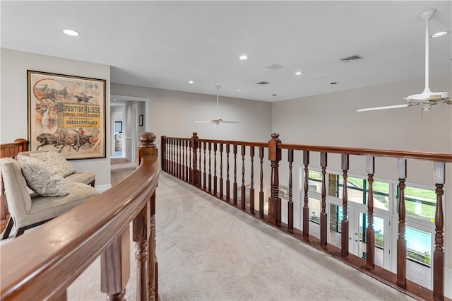 corridor featuring light carpet, visible vents, and recessed lighting