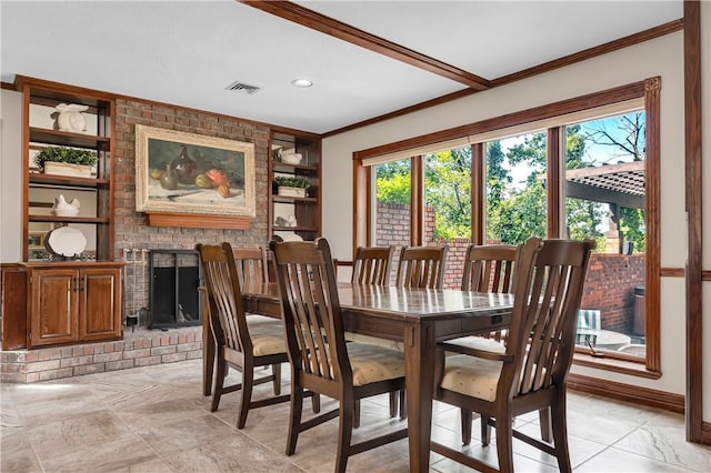 dining space with a brick fireplace, visible vents, baseboards, built in shelves, and ornamental molding