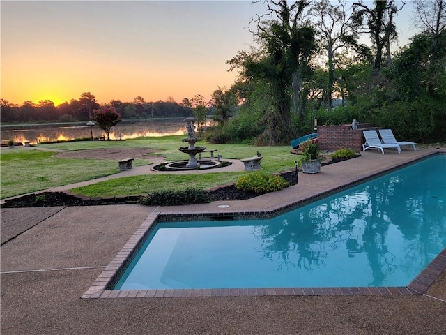 outdoor pool featuring a yard, a patio area, and a water view