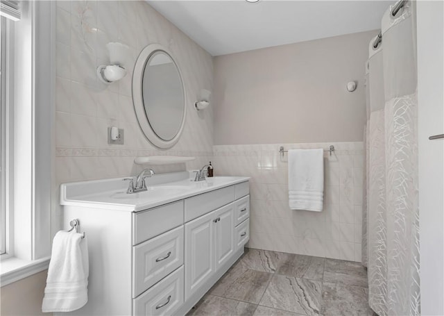 full bathroom with a sink, double vanity, tile walls, and a shower with curtain