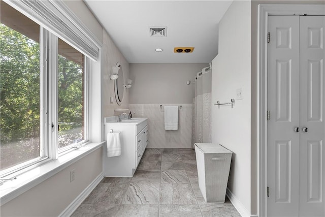 clothes washing area featuring plenty of natural light, baseboards, and visible vents
