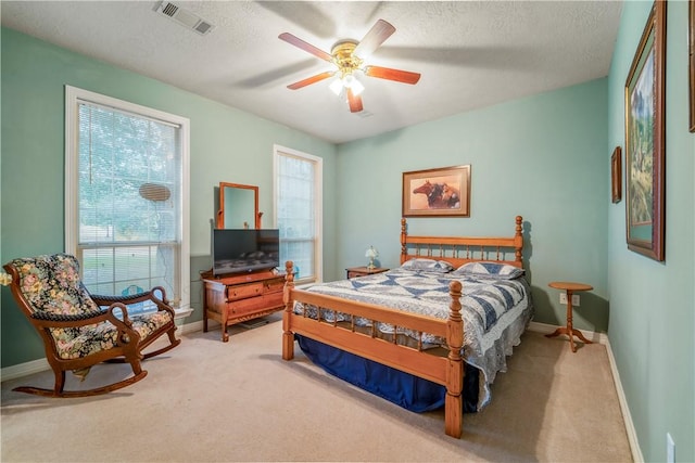 carpeted bedroom with a textured ceiling and ceiling fan