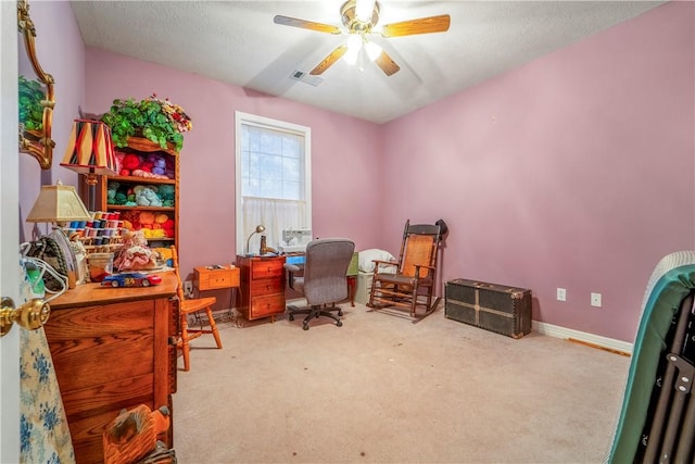 carpeted office space with a textured ceiling and ceiling fan