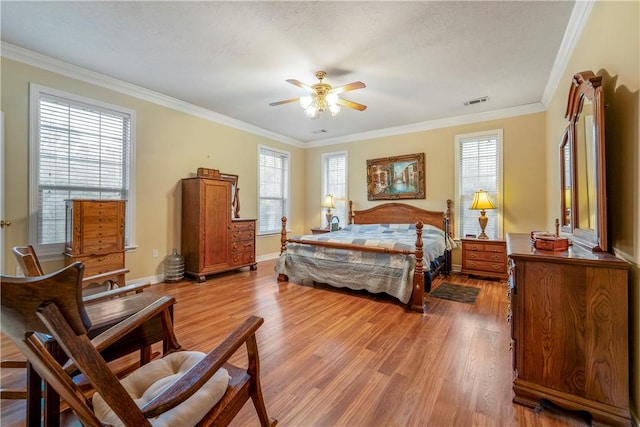 bedroom featuring ceiling fan, crown molding, light hardwood / wood-style flooring, and multiple windows