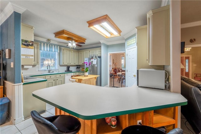 kitchen with kitchen peninsula, crown molding, sink, and cream cabinetry