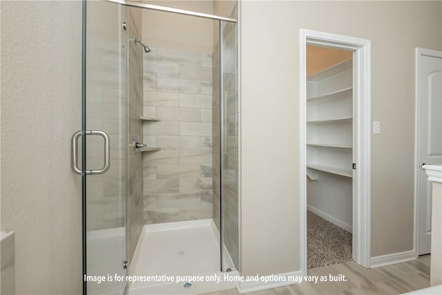 bathroom with hardwood / wood-style flooring and an enclosed shower