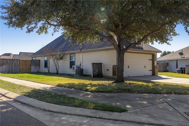 exterior space featuring a front yard, a garage, and central air condition unit