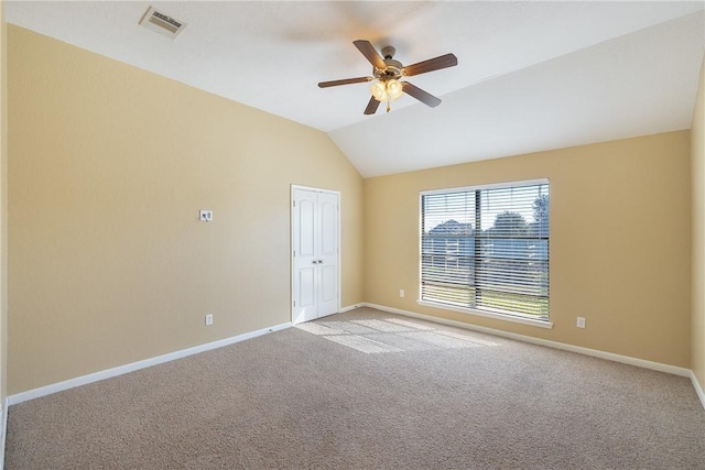 carpeted spare room featuring ceiling fan and vaulted ceiling