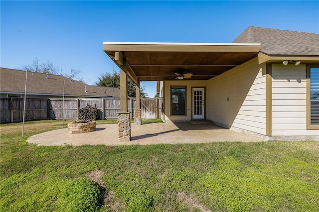 back of house featuring an outdoor fire pit, a patio area, ceiling fan, and a yard