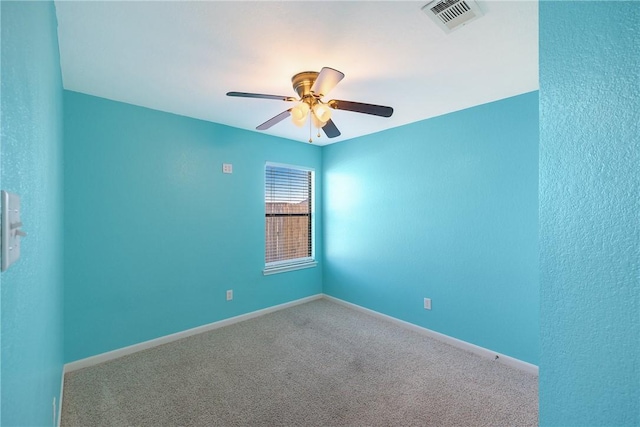 carpeted spare room with ceiling fan