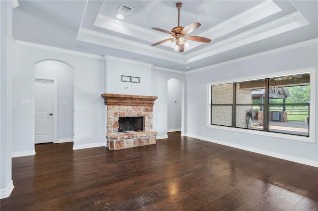 5398 Prairie Dawn Trl, College Station, TX 77845 - unfurnished living room with a ceiling fan, wood finished floors, a fireplace, a tray ceiling, and arched walkways