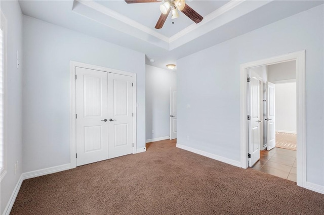 5398 Prairie Dawn Trl, College Station, TX 77845 - unfurnished bedroom with a closet, carpet flooring, baseboards, and a tray ceiling