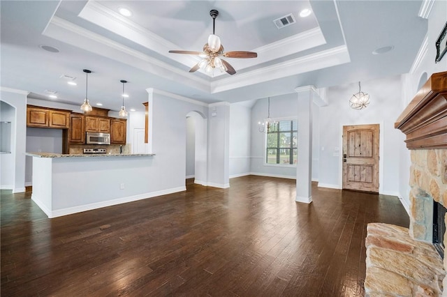 5398 Prairie Dawn Trl, College Station, TX 77845 - unfurnished living room with visible vents, arched walkways, a raised ceiling, and ceiling fan with notable chandelier