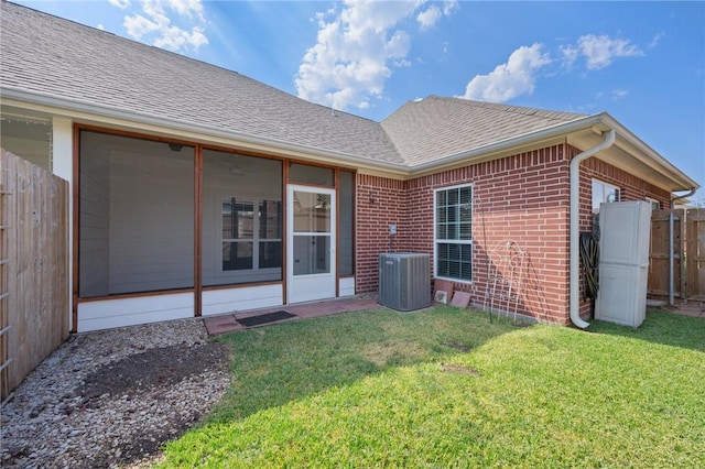 back of house with a lawn and central air condition unit