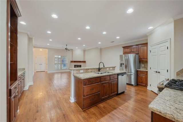 kitchen featuring stainless steel appliances, a kitchen island with sink, light hardwood / wood-style floors, and sink