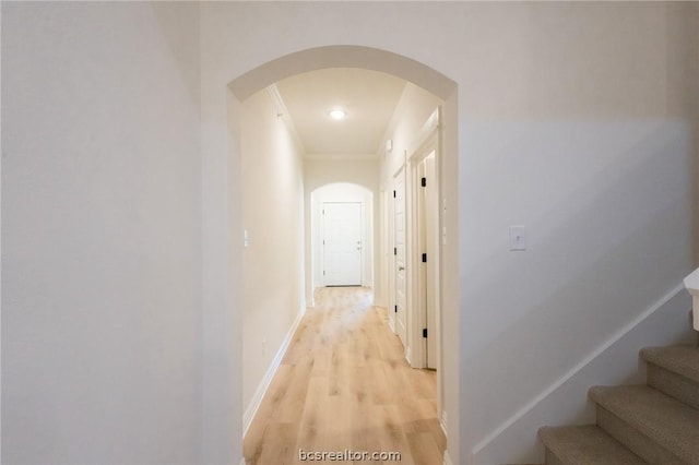 corridor with crown molding and light wood-type flooring