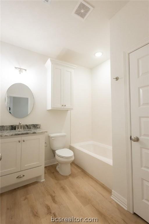 bathroom with hardwood / wood-style flooring, vanity, and toilet