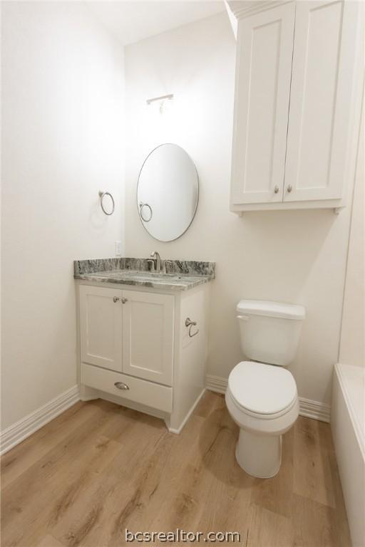 bathroom with vanity, hardwood / wood-style flooring, and toilet